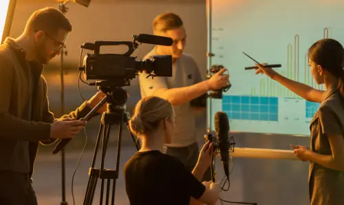 Команда в студии: оператор, звукоинженер и продюсер у камеры